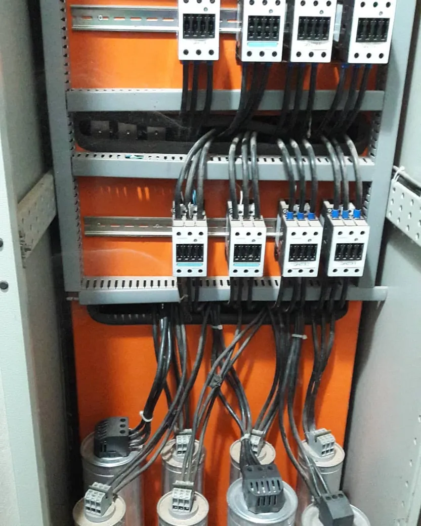 Banco de capacitores industrial montado, com contatores e células capacitivas no painel.