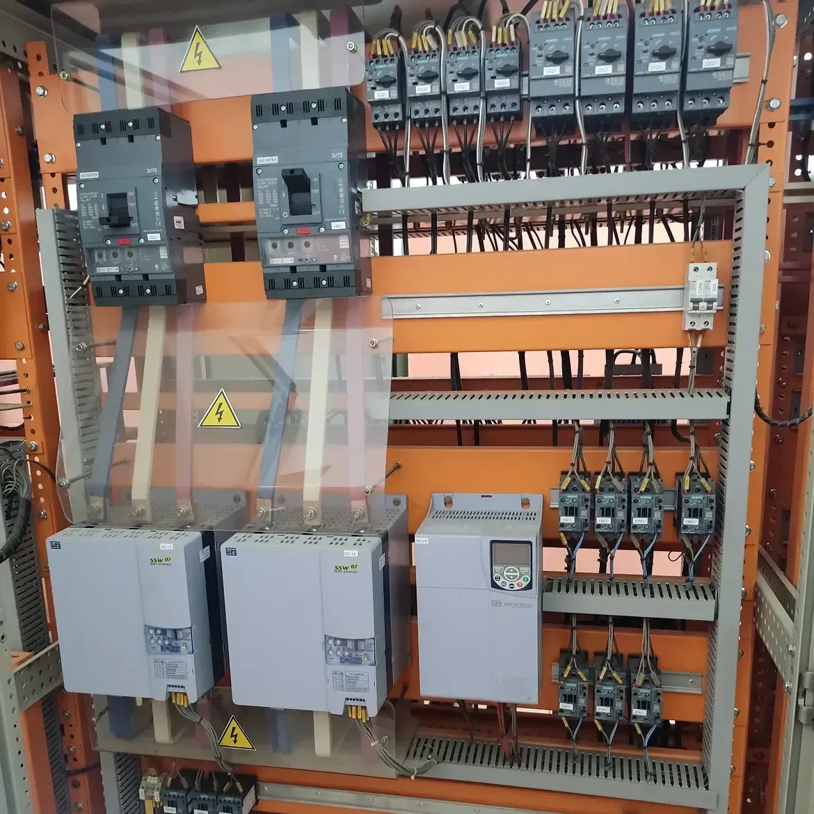 CCM de algodoeira aberto, em manutenção preventiva, com dois disjuntores Siemens 3VT3, oito disjuntores-motor Siemens identificados por circuito, duas soft-starters WEG SSW07 e um inversor de frequência WEG CFW500.