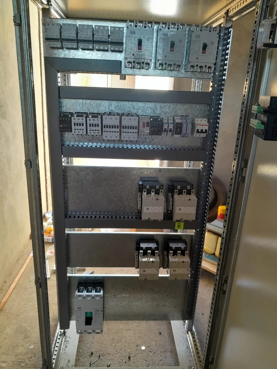 Quadro de comando em fase de montagem, com disjuntores WEG e contatores fixados em trilho, antes da fiação final.