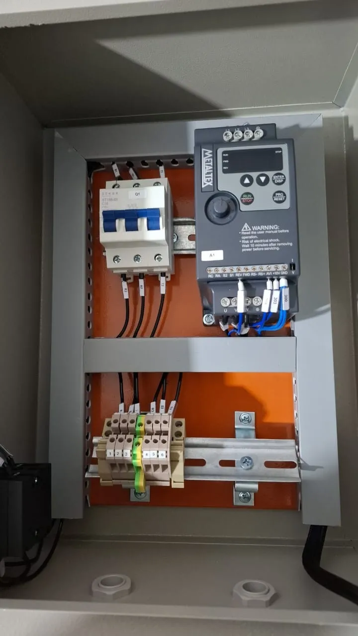 Quadro compacto de sobrepor com um inversor de frequência Metaltex, disjuntor tripolar e régua de bornes numerada.
