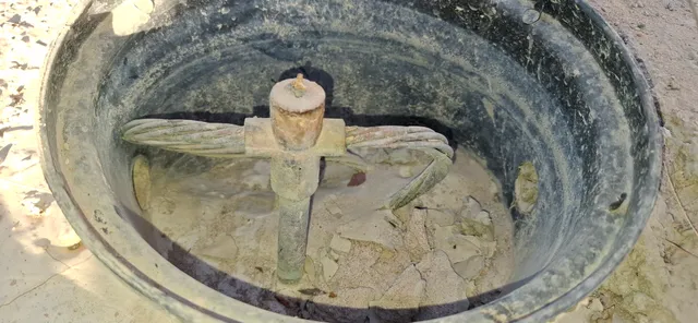 Caixa de inspeção de aterramento aberta, mostrando a haste, o conector de medição e o cabo de cobre nu conectado.