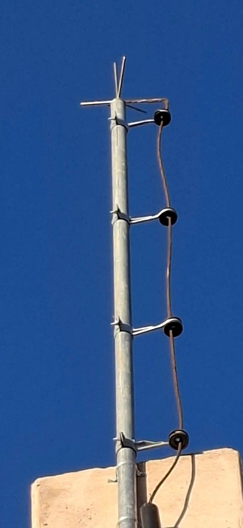 Captor tipo Franklin instalado em mastro, com cabo de descida apoiado em isoladores de roldana ao longo da estrutura.